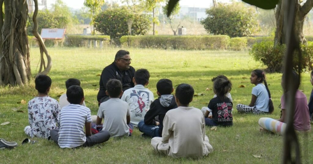 Professor conduzindo atividade de educação ambiental ao ar livre com um grupo de crianças