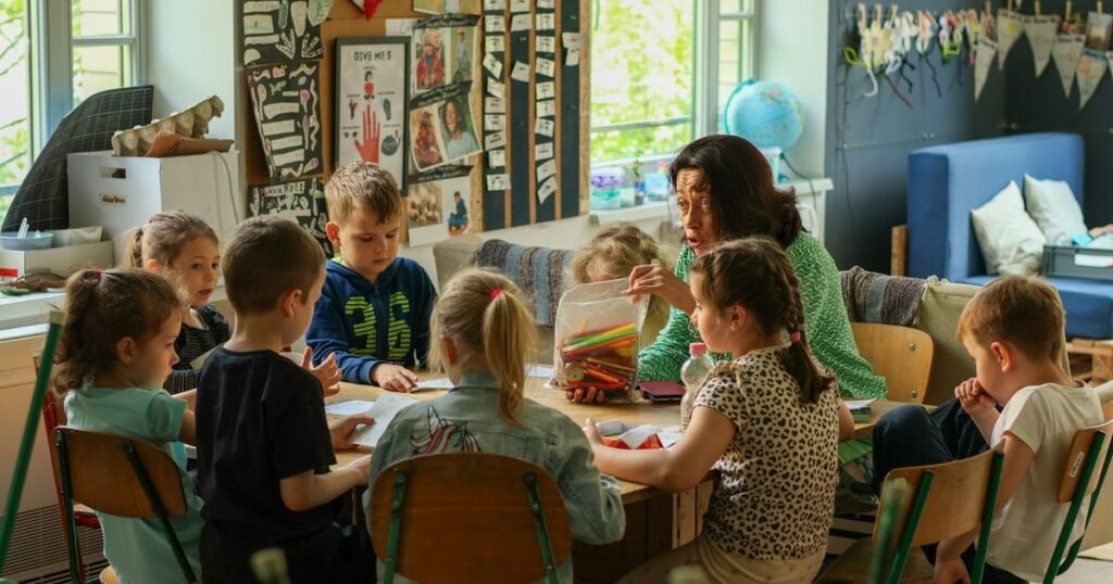 Professora distribui lápis de cor para turma de crianças em aula de Arte