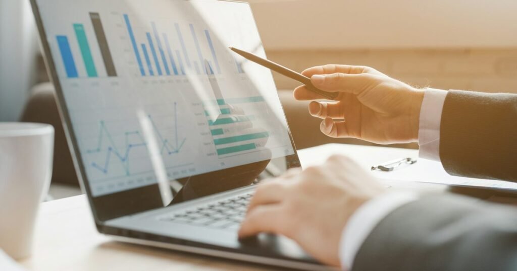 Profissional analisando gráficos financeiros em laptop, MBA em Gestão Financeira